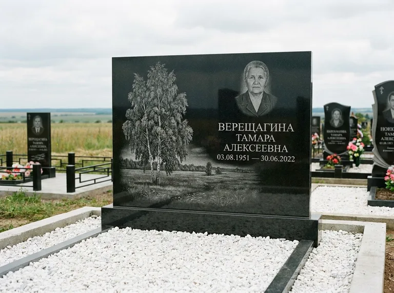 Памятник с гравировкой берёзы: широкая горизонтальная стела — берёза у поля, простор до горизонта, белая мраморная крошка с бордюром, работа «Верещагина» в Мурманске