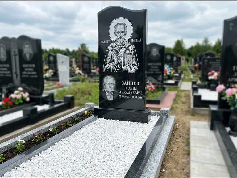 Памятник с гравировкой иконы: стела с крестообразным навершием — икона в резной рамке-киоте, газон без ограды, стриженая трава, работа «Раевская» в Мурманске