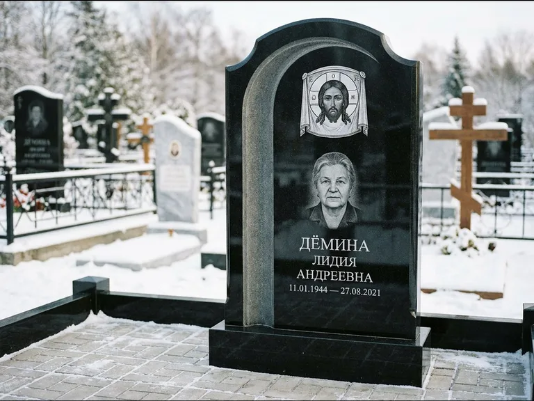 Памятник с гравировкой иконы: гранёный восьмиугольный обелиск с крестом — гравировка Николая Чудотворца, семейный участок с гранитной скамьёй, работа «Зотов» в Мурманске