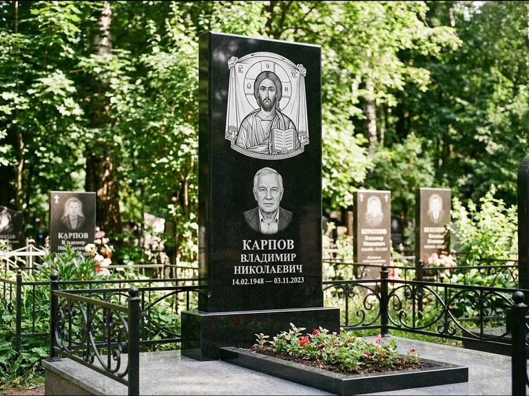 Памятник с гравировкой иконы: широкая двойная семейная стела — золочёный нимб на образе, цветник с красными розами, работа «Воронцова» в Мурманске