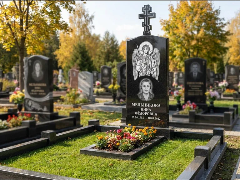 Памятник с гравировкой иконы: округлая стела-медальон с ликом — гравировка Богородицы «Семистрельная», луговые травы и полевые цветы за участком, работа «Гущин» в Мурманске
