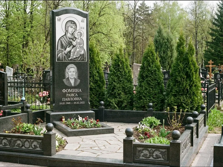 Памятник с гравировкой иконы: высокий гранёный обелиск с крестом-навершием — гравировка образа Матроны Московской, открытый участок без ограды, работа «Третьяков» в Мурманске