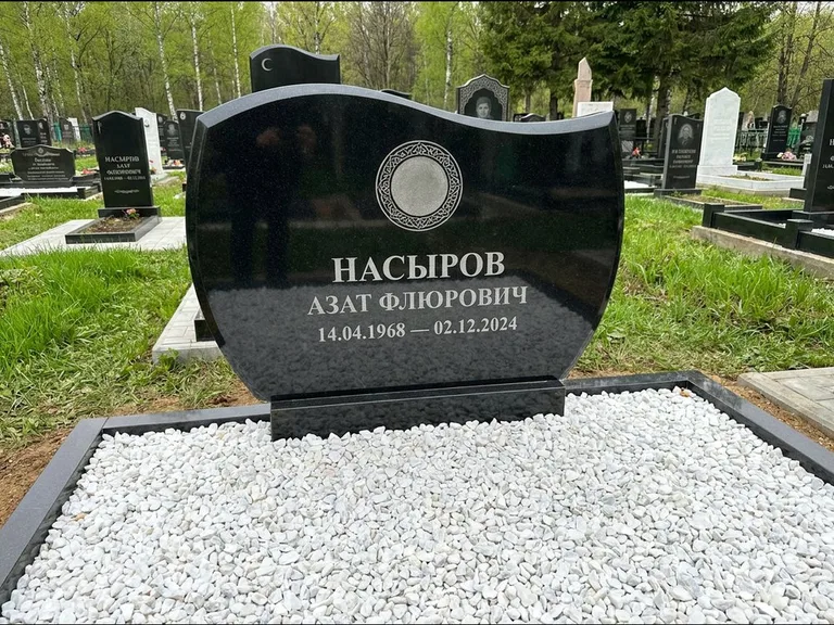 Мусульманский памятник: стела с волнообразным скошенным верхом — гравировка мечети под полумесяцем и звёздами, белая мраморная крошка с бордюром, работа «Насыров» в Мурманске