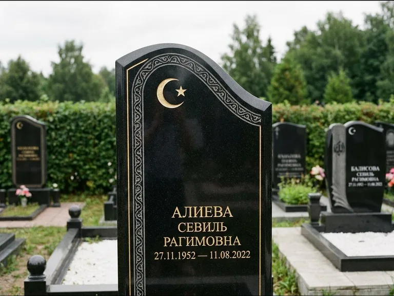Мусульманский памятник: асимметричная скошенная стела — белая гравировка силуэта мечети с минаретами, живая изгородь из кустарника, работа «Алиева» в Мурманске