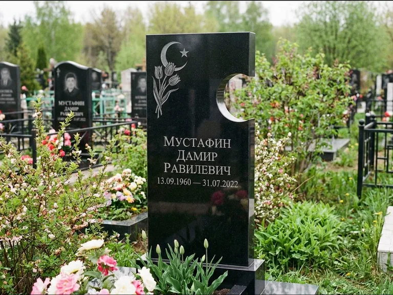 Мусульманский памятник: стела с боковым вырезом в форме полумесяца — гравировка минарета с полумесяцем, низкие кусты в цвету, работа «Мустафин» в Мурманске