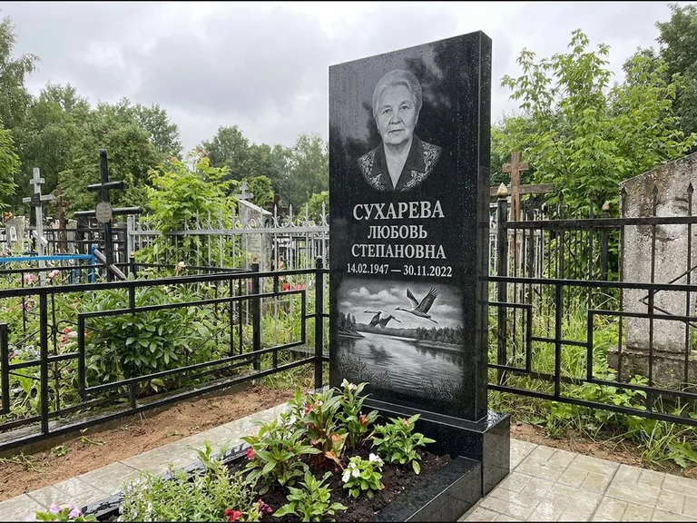 Памятник с гравировкой журавлей — гравировка пары журавлей над гладью озера в нижней части, работа «Сухарева» в Мурманске
