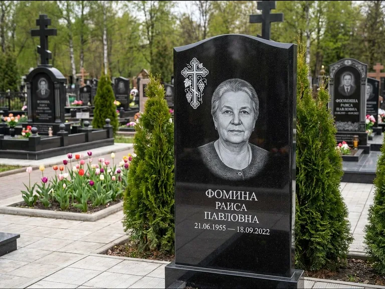 Памятник из чёрного гранита — двухцветная стела с крестом с распятием, работа «Одинцова» в Мурманске