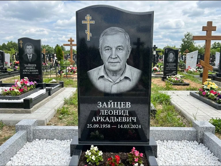 Памятник из чёрного гранита — горизонтальная семейная стела с аркой с процветшим крестом с виноградной лозой, работа «Верещагин» в Мурманске