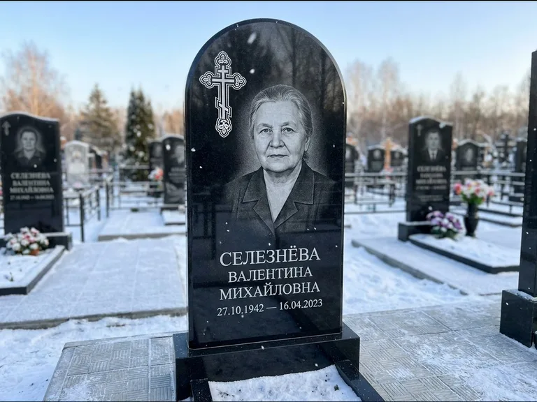Памятник из чёрного гранита — массивная стела с крестом в лучах с крестом в лучах, работа «Одинцова» в Мурманске