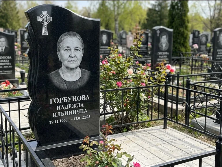 Памятник из чёрного гранита — высокий обелиск с кельтским крестом, работа «Одинцова» в Мурманске
