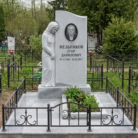 Памятник со скульптурой скорбящей матери из серого гранита